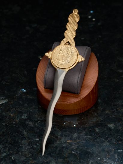Gilded metal letter opener centered on a...