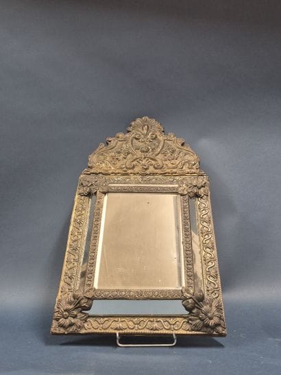 Miroir à parecloses en métal repoussé.
Dans...