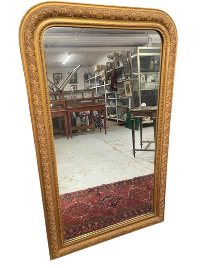 Grand miroir en bois et stuc doré à bords...