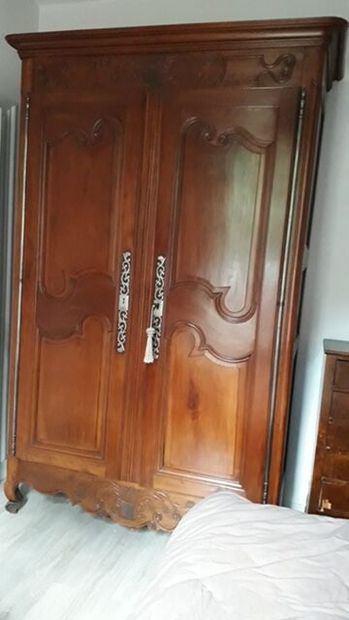 An armoire in molded natural wood carved...