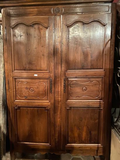 A molded oak armoire carved with rosettes...