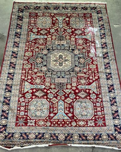 IRAN - Un tapis en laine à fond rouge et...