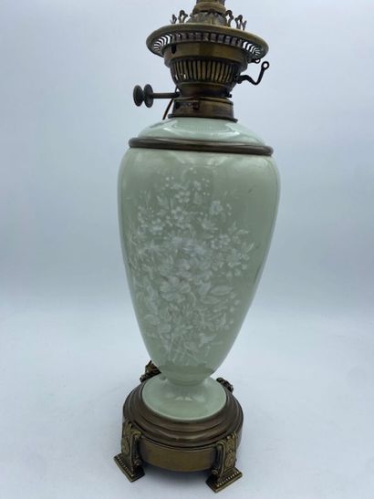 An ovoid earthenware oil lamp with a celadon...