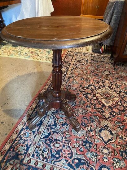 A pedestal table with damaged legs in natural...