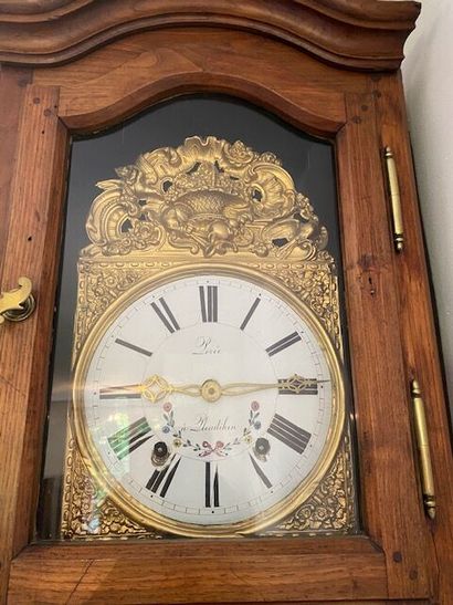 A natural wood floor clock with a PLENAHIER...