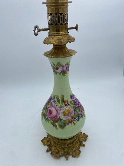 A kerosene lamp with a porcelain body decorated...