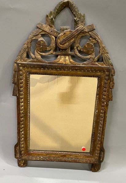 A gilded carved wood pediment mirror decorated...