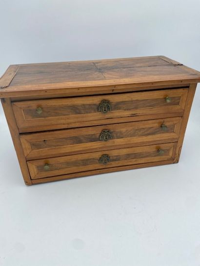 A walnut and rosewood veneered doll's chest...