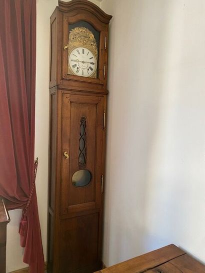 A natural wood floor clock with a PLENAHIER...