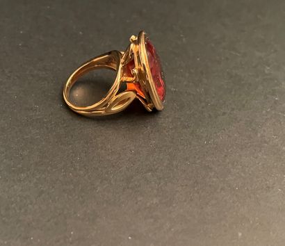Bague ornée d'une pierre orangée ovale montée...