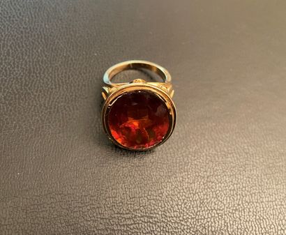 Bague ornée d'une pierre orangée ovale montée...