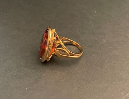 Bague ornée d'une pierre orangée ovale montée...