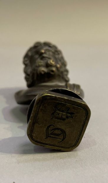 Bronze seal surmounted by a bust of Zeus.
End...