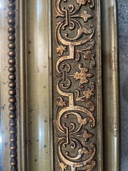 Gilded stucco mirror, the upper angles rounded,...