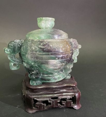 Covered pot, the handles in the shape of...