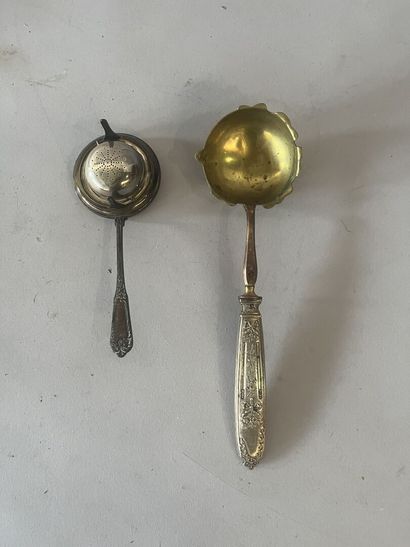 A silver-handled ladle and a silver tea strainer....