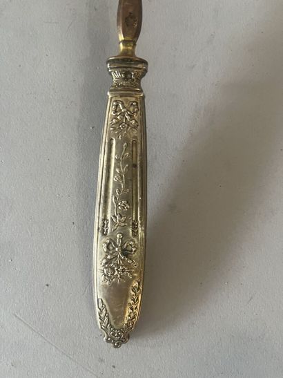 A silver-handled ladle and a silver tea strainer....