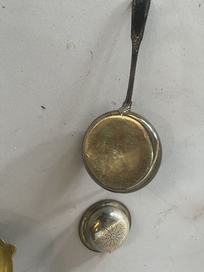 A silver-handled ladle and a silver tea strainer....