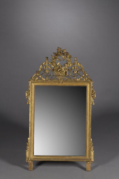 Miroir en bois sculpté et doré ; le fronton...