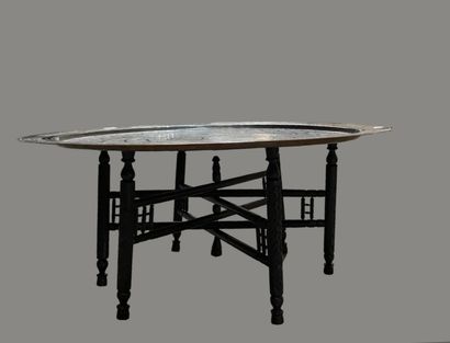 Round engraved brass top. 
Black wooden legs.
Maghreb,...