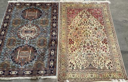 Two rugs : 
- an oriental silk carpet on...