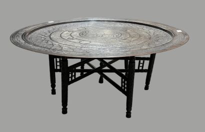 Round engraved brass top. 
Black wooden legs.
Maghreb,...