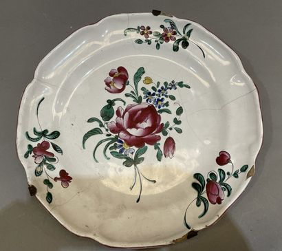 Quatre assiettes en faïence à décor de roses....