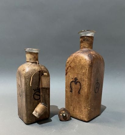 Deux bouteilles en verre gaînées de cuir...