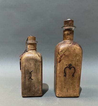 Deux bouteilles en verre gaînées de cuir...