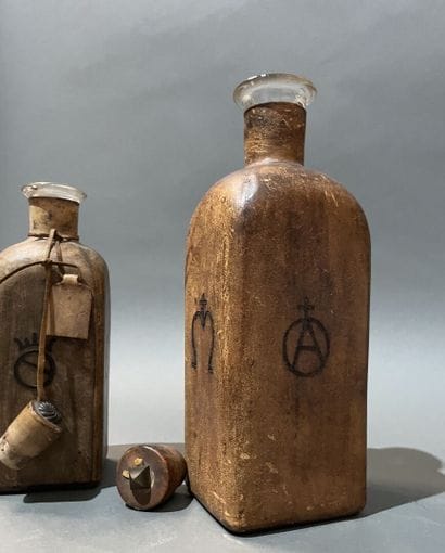 Deux bouteilles en verre gaînées de cuir...