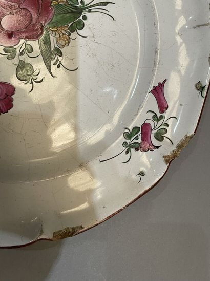 Quatre assiettes en faïence à décor de roses....