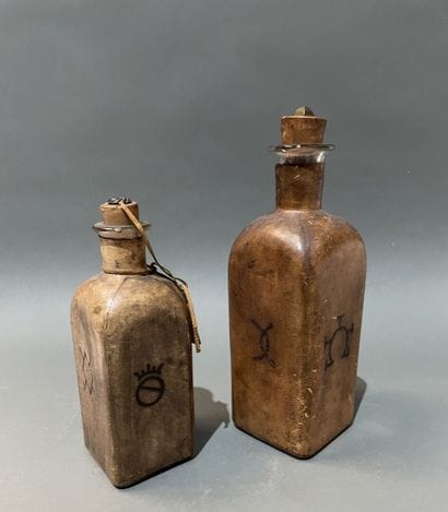 Deux bouteilles en verre gaînées de cuir...