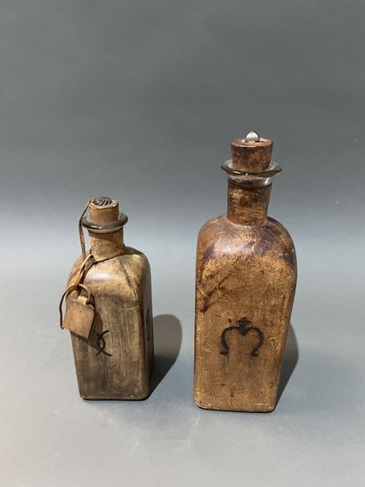 Deux bouteilles en verre gaînées de cuir...