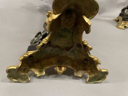 Pair of tripod candelabra in patinated and...