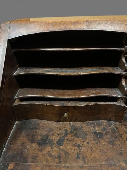 Natural wood sloping desk opening to a flap...