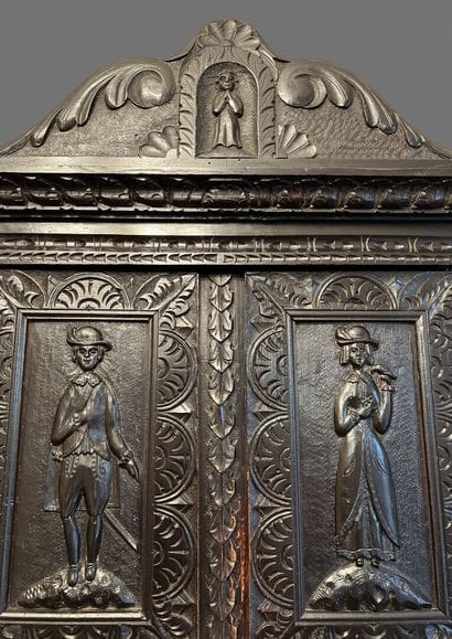 Dark patina wood cabinet with leafy moldings,...