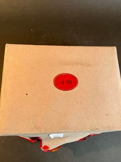 Toiletries in a suitcase in a red leather-lined...