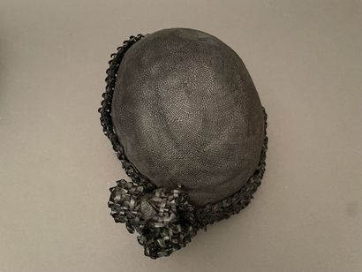 Black straw hat with raffia ornamentation
Circa...