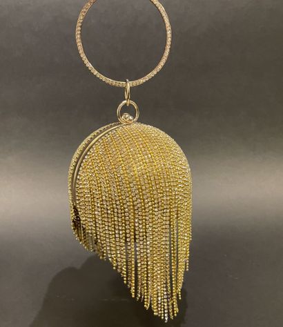 A rigid clutch bag shaped like a golden sphere,...