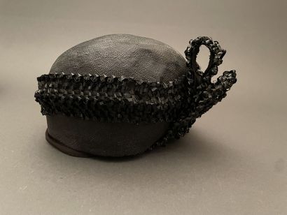 Black straw hat with raffia ornamentation
Circa...