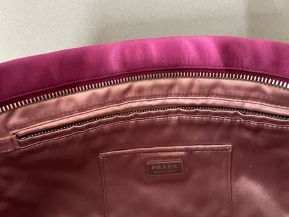 PRADA 
Burgundy satin clutch with a zipper...