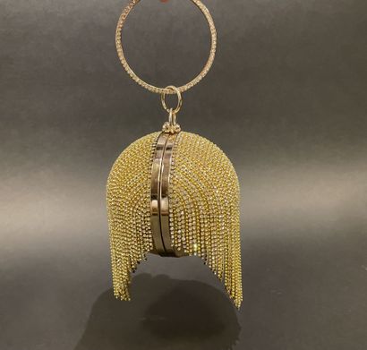 A rigid clutch bag shaped like a golden sphere,...