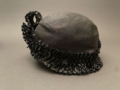 Black straw hat with raffia ornamentation
Circa...