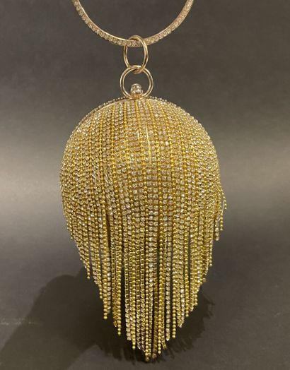 A rigid clutch bag shaped like a golden sphere,...