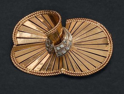 Broche ovoïde formant des volutes en or jaune...