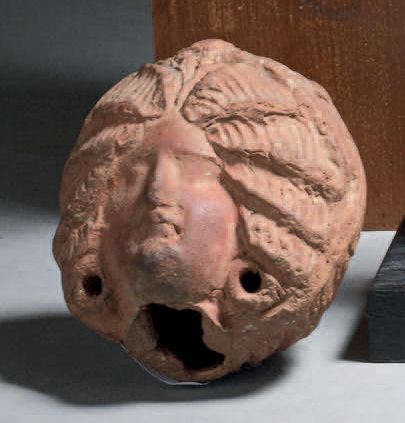 Tête de femme à la coiffure élaborée.
Terre-cuite...