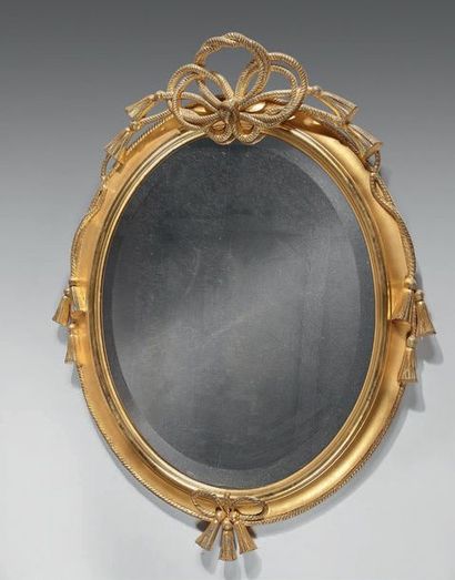 Mirror with oval frame in gilded wood, decorated...