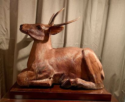 Sculpture of a deer lying in carved wood...