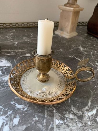 A golden brass candleholder with a frieze...