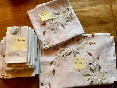 Two white embroidered tablecloths with flower...